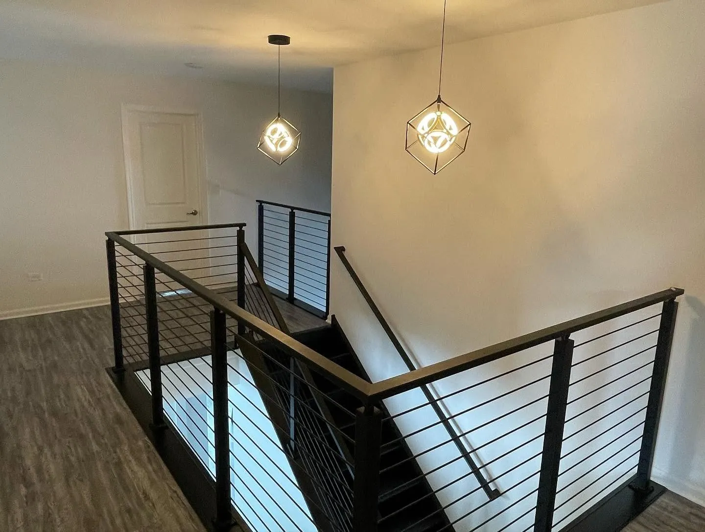 Modern black horizontal-rod railing with wood cap